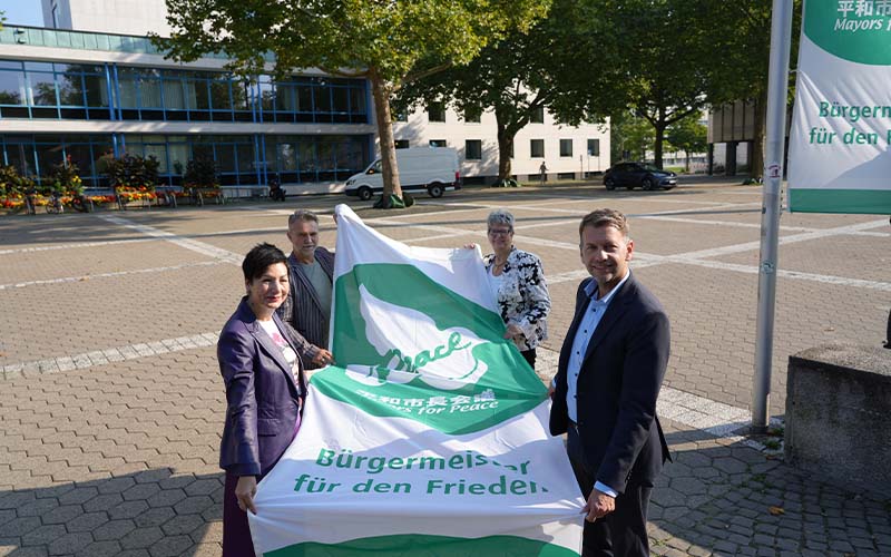 Oberbürgermeister Dennis Weilmann sowie die Bürgermeister*innen Immacolata Glosemeyer, Angelika Jahns und Andreas Klaffehn hissten kürzlich auf dem Rathausplatz Flaggen für den Frieden.